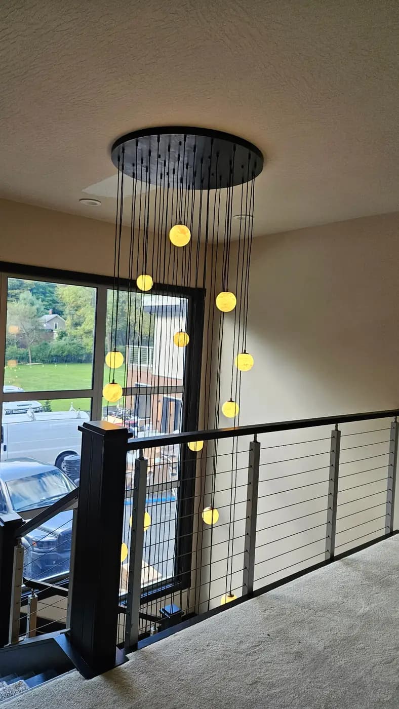 Finished stairwell with cable railing and pendant lights